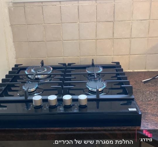 כיריים על משטח שיש חום כהה במטבח